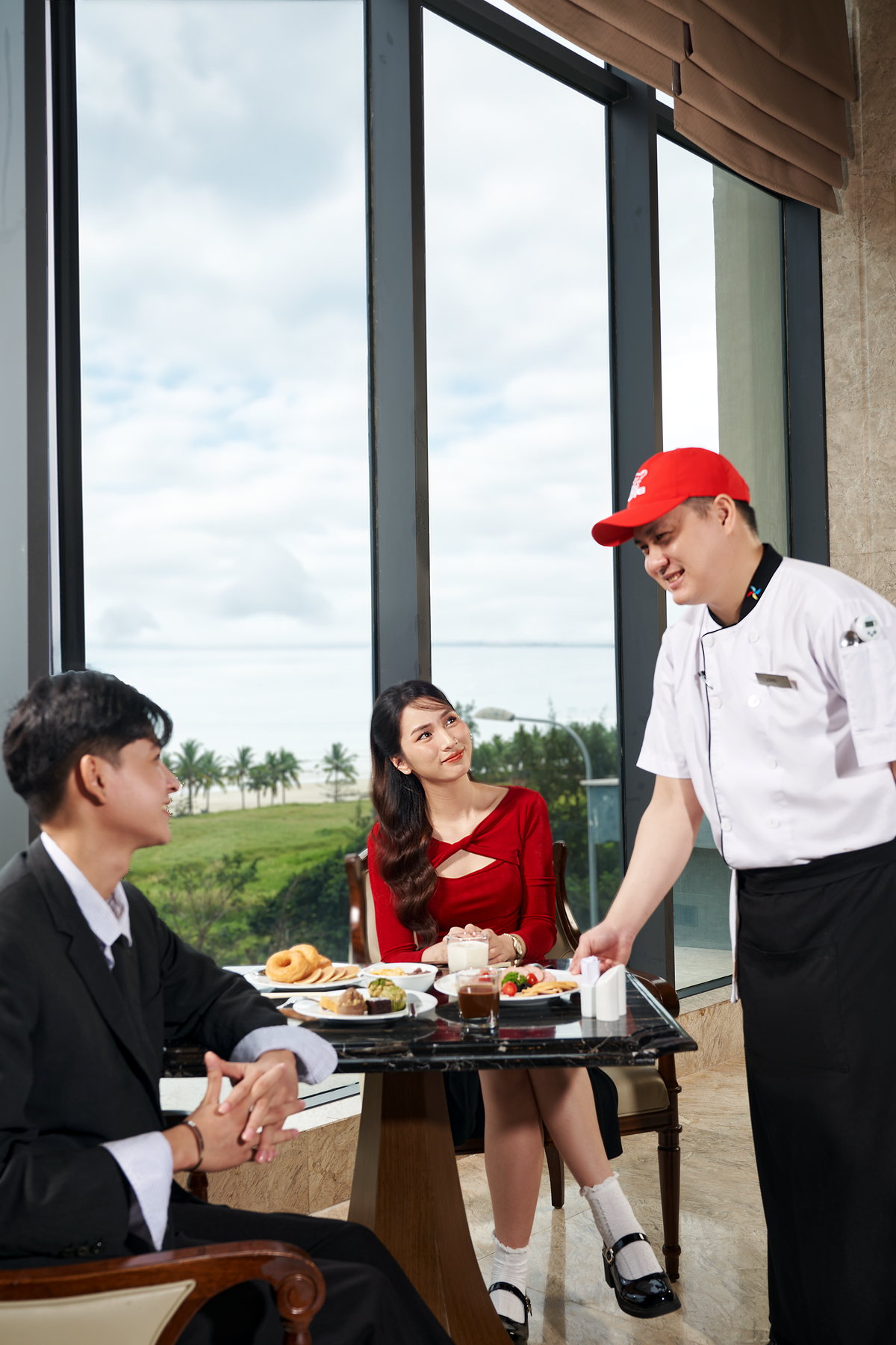 Đầu bếp trao đổi với hai vị khách bên bàn ăn