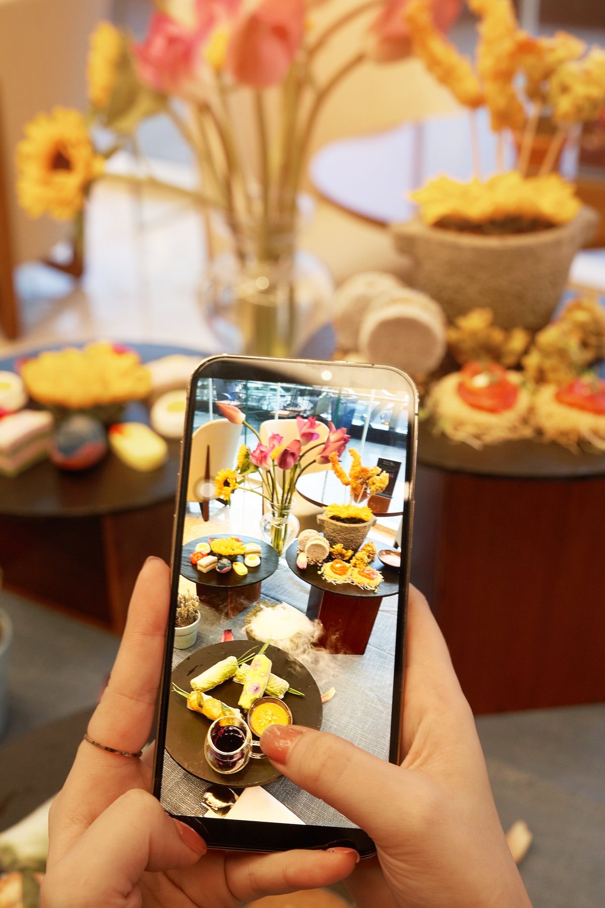 Một vị khách chụp bộ Floral High Tea bằng điện thoại tại Four Points Danang