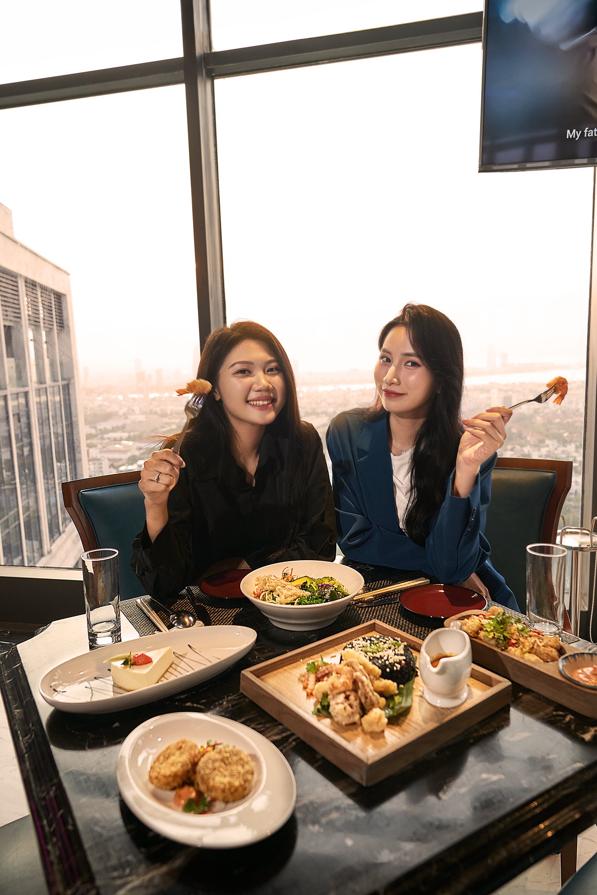 Hai người bạn nâng ly bên bàn ăn tại Four Points by Sheraton Danang