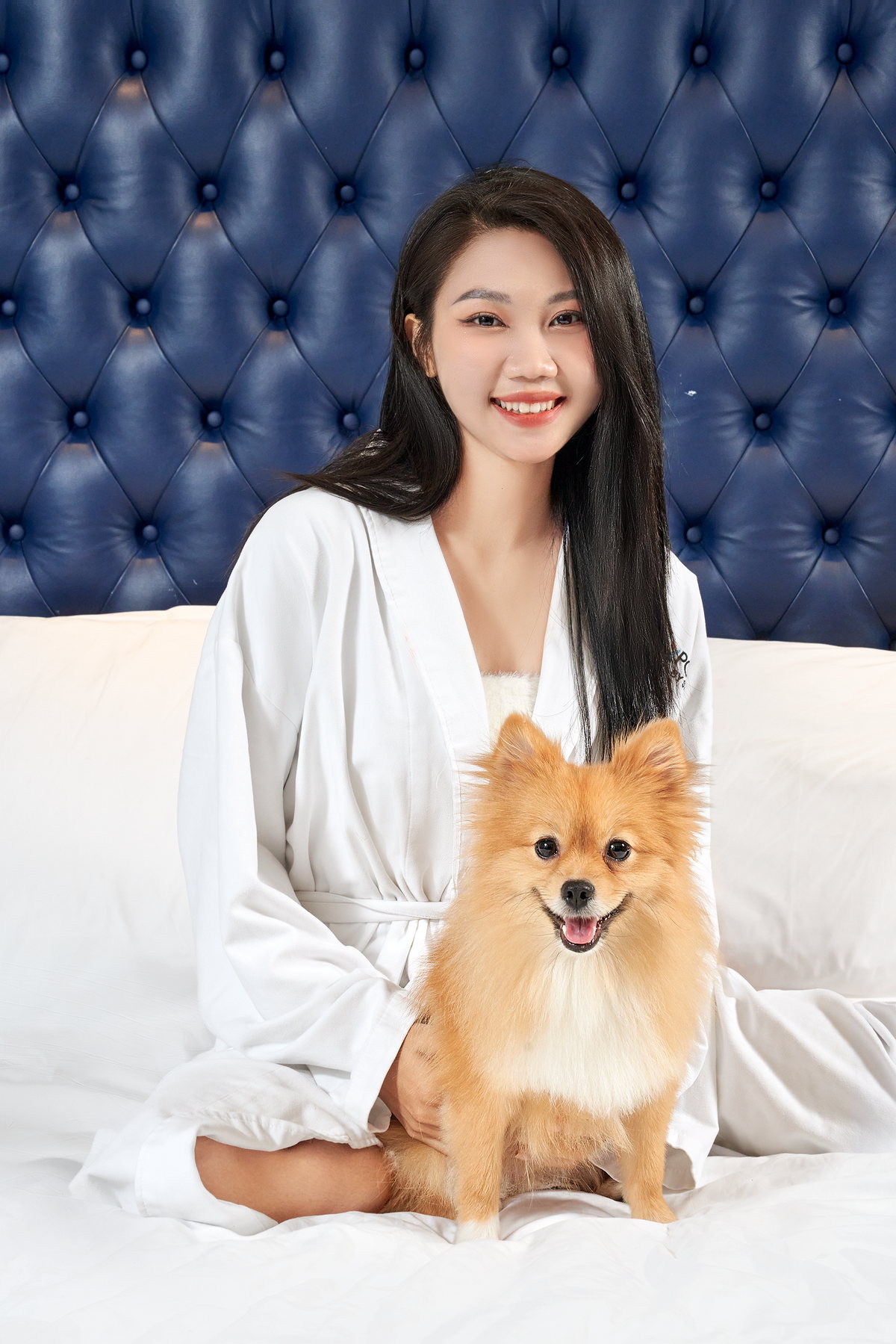 Một vị khách ngồi trên giường cùng chú chó nhỏ