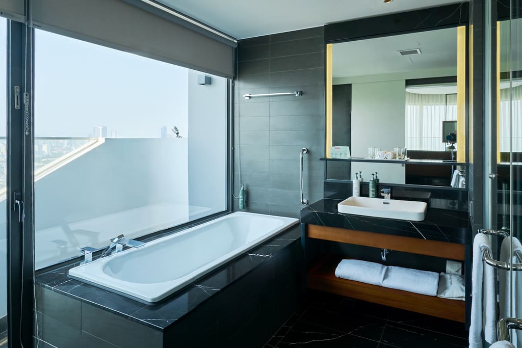 Phòng tắm có bồn và cửa kính tại Hilton Garden Inn Đà Nẵng
