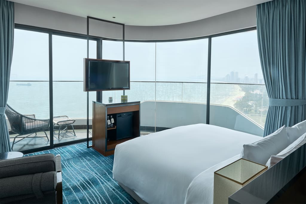 Phòng góc Hilton Garden Inn Đà Nẵng với giường lớn và cửa kính nhìn ra biển