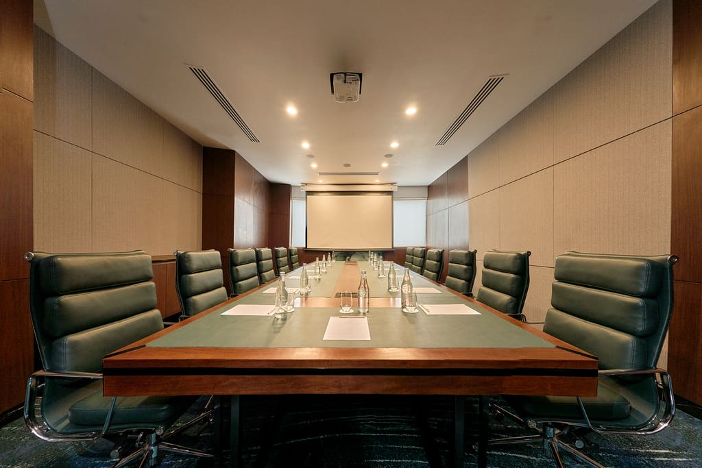 Phòng họp điều hành Hilton Garden Inn Đà Nẵng với bàn dài và màn chiếu