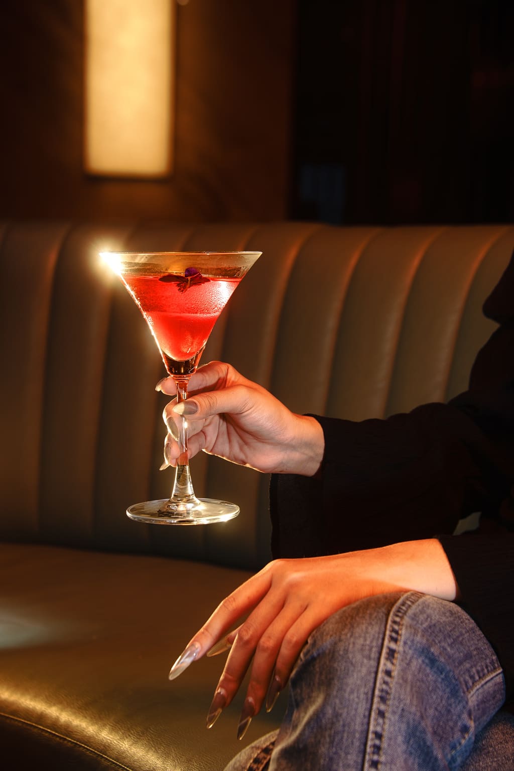 Khách cầm ly cocktail đỏ trong không gian nhà hàng khách sạn