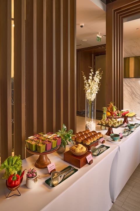 Quầy tiệc tự phục vụ của Hilton với bánh, món cuốn và trái cây