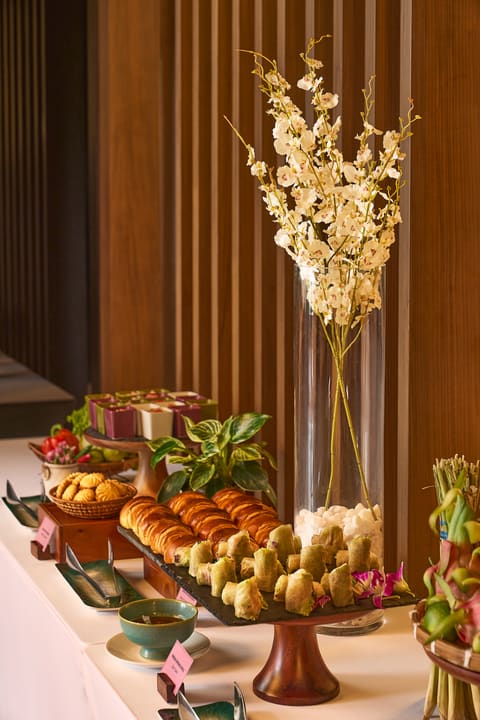 Cận cảnh bánh và món cuốn trên buffet sự kiện Hilton