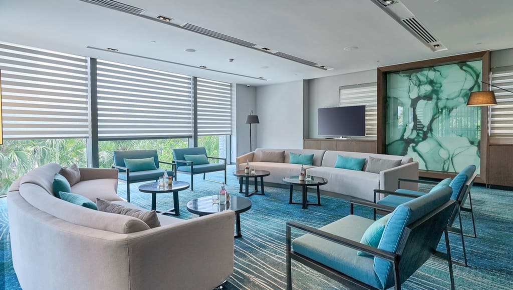Khu tiếp khách sự kiện Hilton Garden Inn Đà Nẵng với sofa và ghế tông xanh