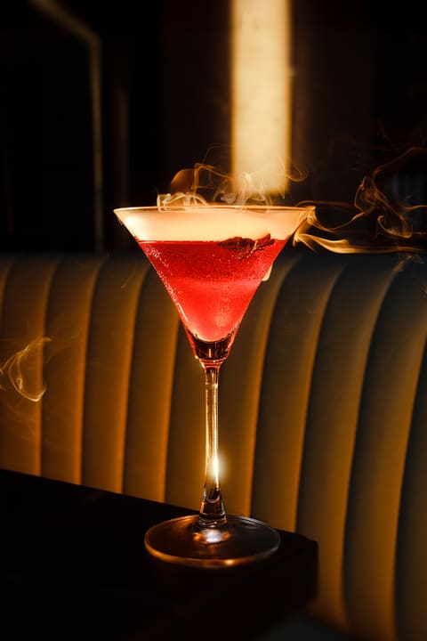 Ly cocktail màu đỏ được chiếu sáng trong không gian tối
