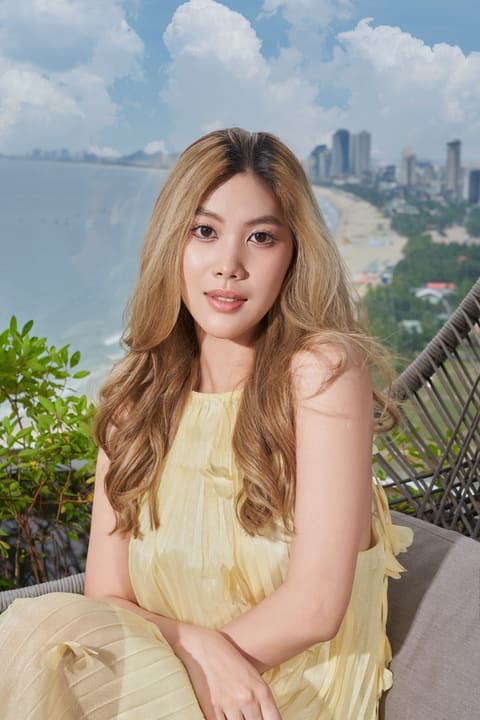 Chân dung khách nữ trên ban công với đường bờ biển phía sau