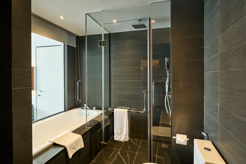 Phòng tắm khách sạn với gương, lavabo và khu tắm
