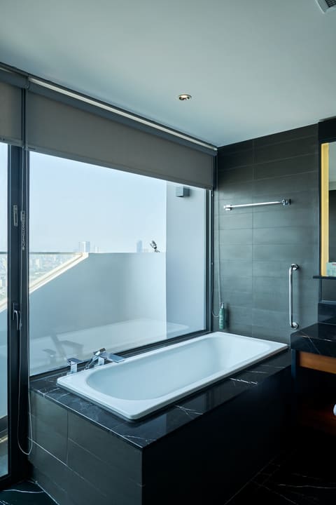 Bồn tắm cạnh cửa kính trong phòng tắm Hilton Garden Inn Đà Nẵng