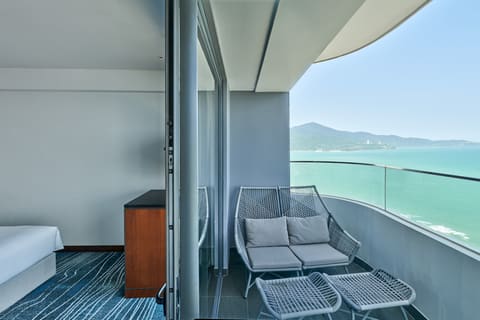 Ban công phòng nghỉ Hilton Garden Inn Đà Nẵng với ghế đôi nhìn ra biển