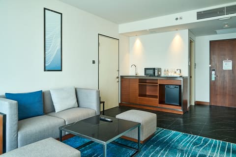 Phòng khách suite Hilton Garden Inn Đà Nẵng với sofa và khu bếp nhỏ