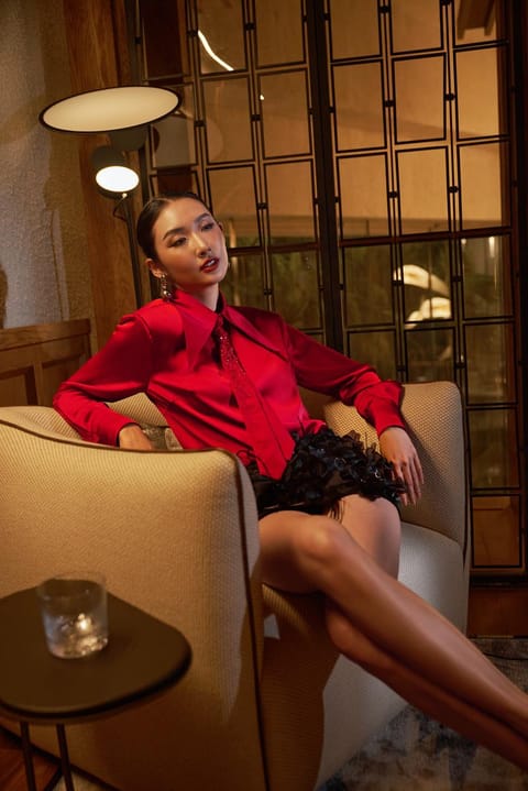 Người mẫu XITA mặc trang phục đỏ ngồi trong không gian Hoiana