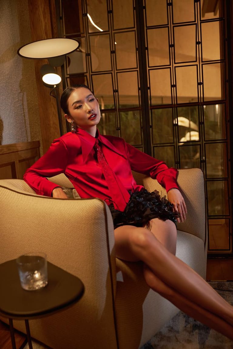 Người mẫu XITA mặc trang phục đỏ ngồi trong không gian Hoiana