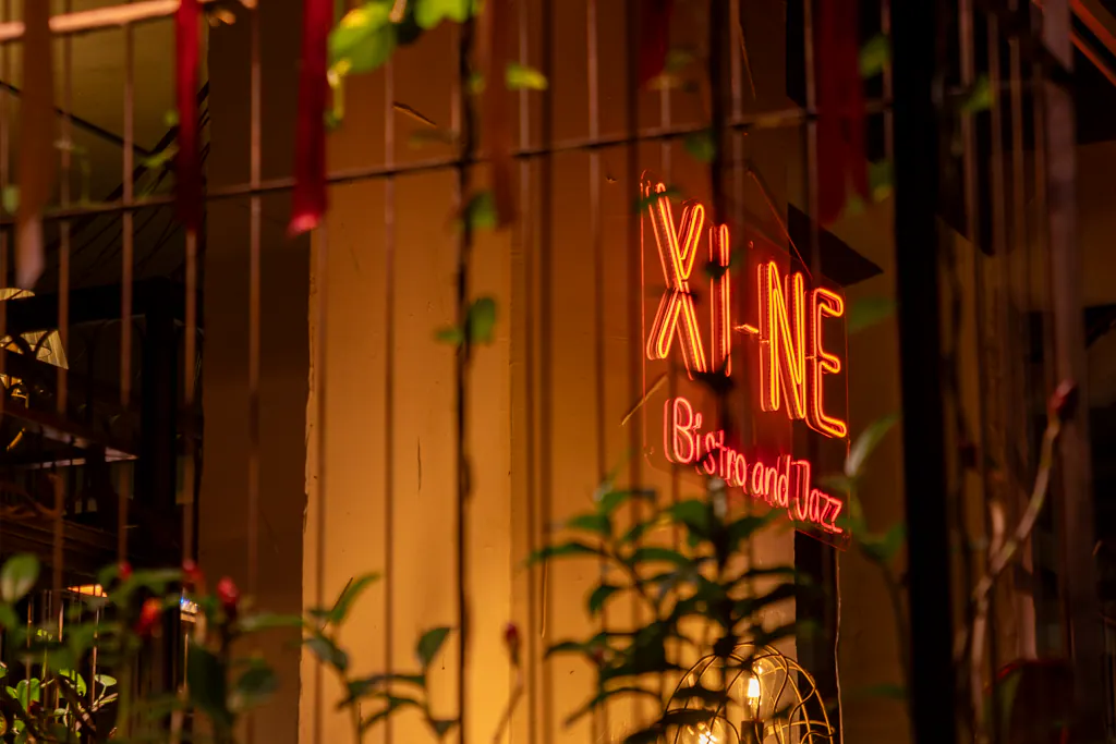 Bảng hiệu Xi Nê Bistro & Jazz rực sáng giữa mảng cây xanh